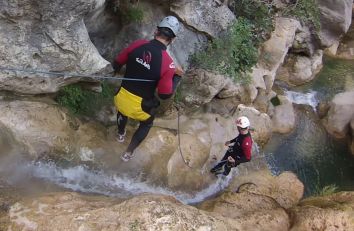 Due esploratori si avventurano in un percorso di canyoning immerso nella natura.