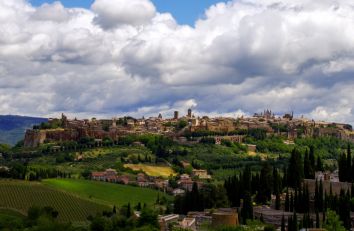 Scena di un antico borgo collinare, circondato da verde e natura.