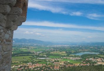 Un panorama su una valle verde, circondata da montagne e un paesaggio tranquillo.