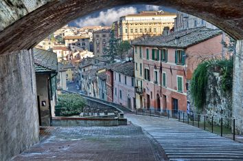 Scena di una tranquilla strada in un antico borgo, con edifici colorati che caratterizzano l'architettura storica.