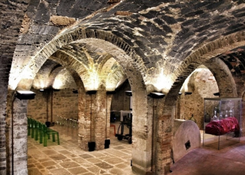 Un ambiente tranquillo con archi in pietra, illuminato da una luce morbida. Un esempio di architettura storica.