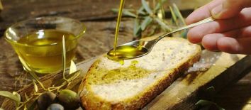 Tour dei borghi umbri in 5 giorni: degustazione di olio extravergine di oliva in frantoio. Umbria my Love - Una fetta di pane con olio d'oliva, servita con olive. Un piatto classico e delizioso.