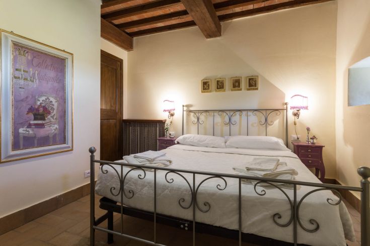 Camera semplice con letto matrimoniale e arredi discreti.