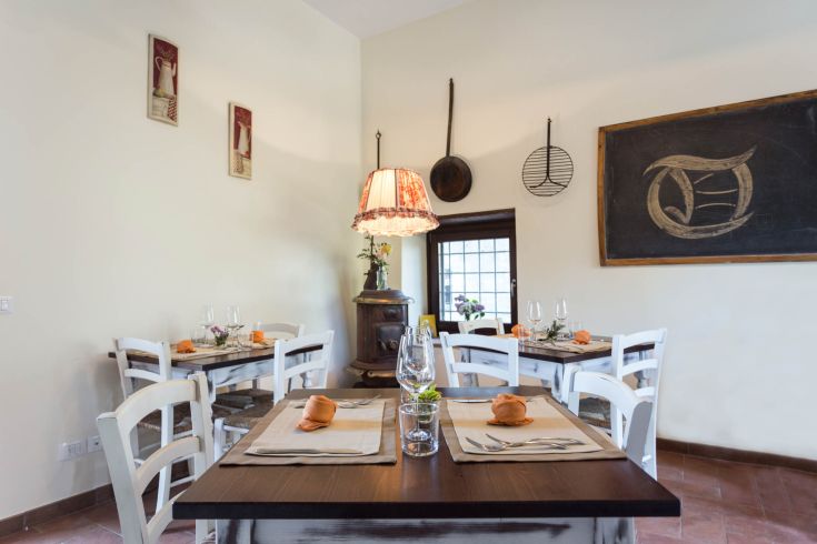 Una sala da pranzo con tavoli ben apparecchiati e un'atmosfera calda e rustica.