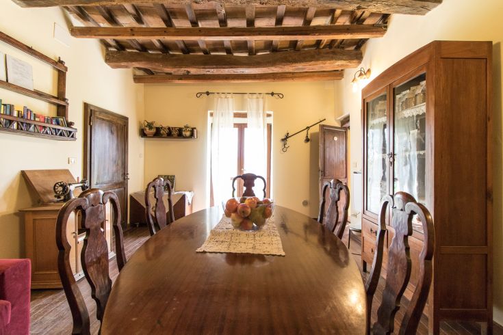 Ampia sala da pranzo con tavolo ovale e decorazioni classiche, accogliente e ben illuminata.