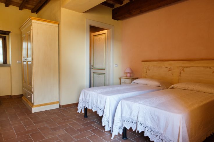 Einfaches Zimmer mit zwei Einzelbetten und traditioneller Einrichtung. Perfekt für einen komfortablen Aufenthalt.