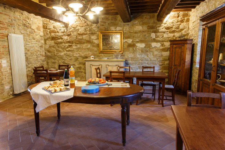 Geräumiges rustikales Esszimmer mit Steinwänden und einem schön gedeckten Tisch für eine angenehme Mahlzeit.