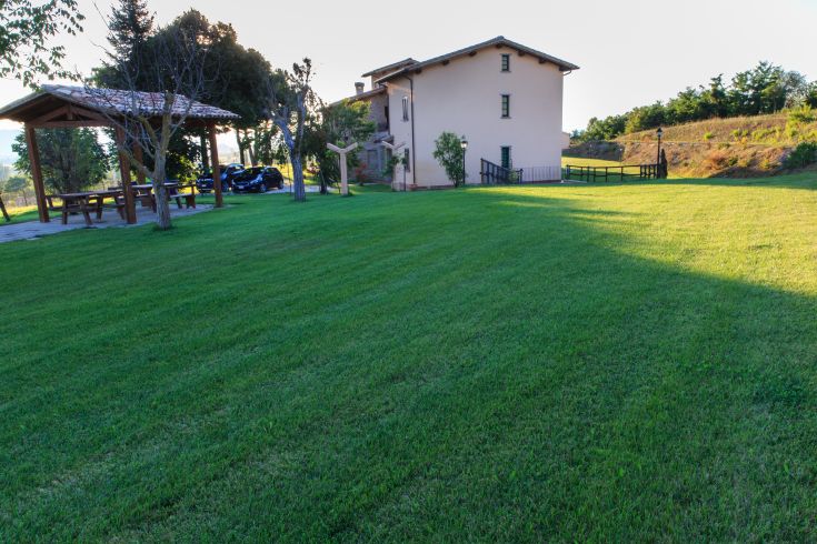 Bauernhaus in einer grünen Umgebung, mit Entspannungsbereichen und atemberaubenden Ausblicken.