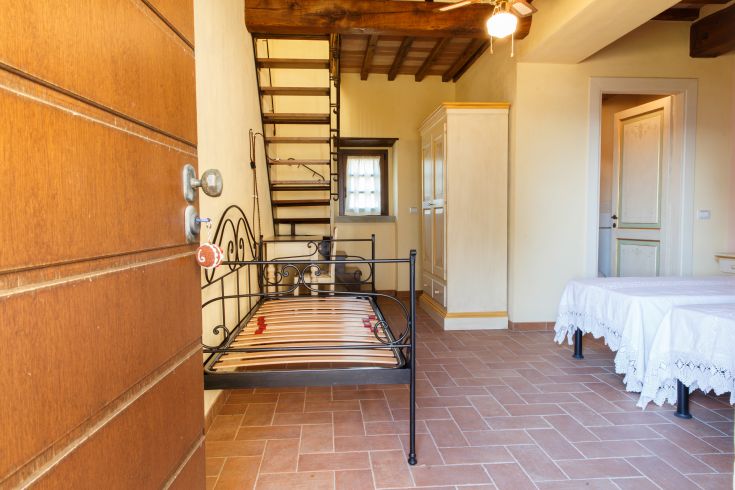 Ein gemütlicher und heller Agriturismusraum mit Bett und Treppe.