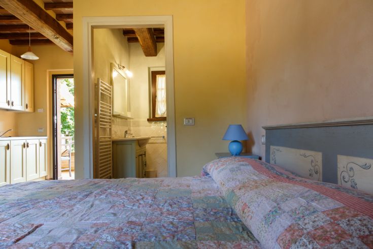 Gemütliches Zimmer mit einfachem Bett, eigenem Bad und Küchenzeile. Ruhige und komfortable Umgebung.