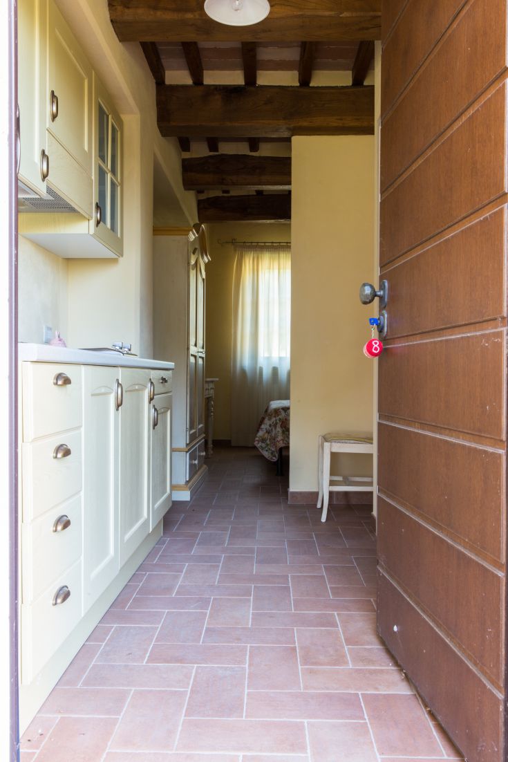 Eingang einer gemütlichen Wohnung mit Küche und Blick auf einen hellen Bereich.