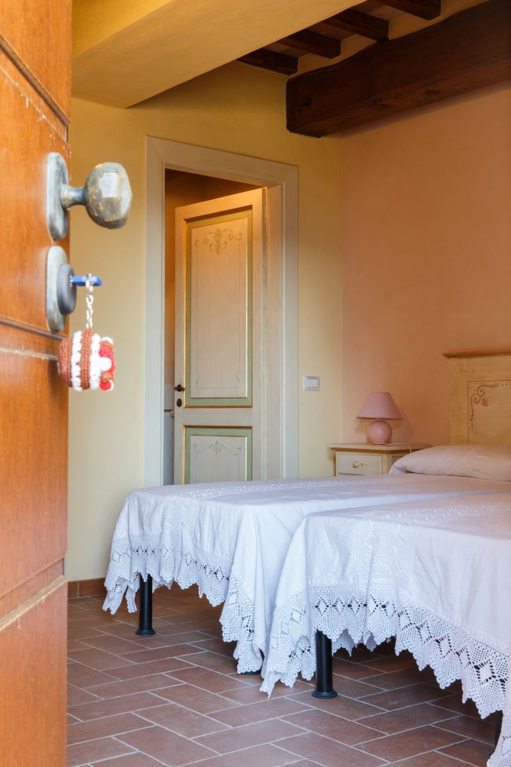 Helle Zimmer mit weißen Betten und rustikalen Details, ideal für einen ruhigen Aufenthalt.