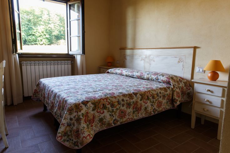 Gemütliches Agriturismo-Zimmer mit Blick auf die Natur und traditioneller Einrichtung.