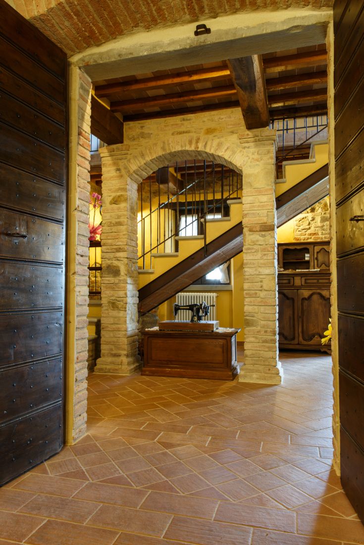 Gemütliches Innere eines Bauernhofs mit Holztreppen und Bögen, die die lokale Tradition widerspiegeln.