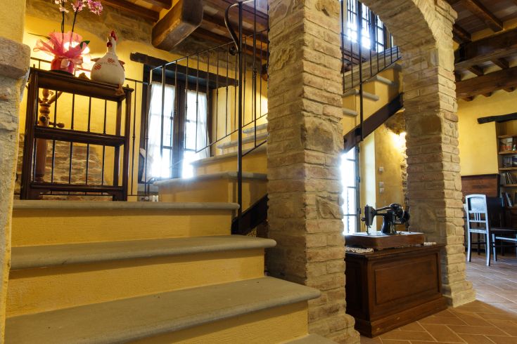 Innenraum eines Bauernhofs mit Treppen und Vintage-Elementen in einer einladenden Umgebung mit gelben Wänden.