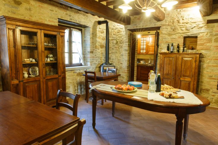 Innenraum eines Agrartourismus mit einfachem Holzinterieur und einem Tisch, der eine familiäre Atmosphäre schafft.