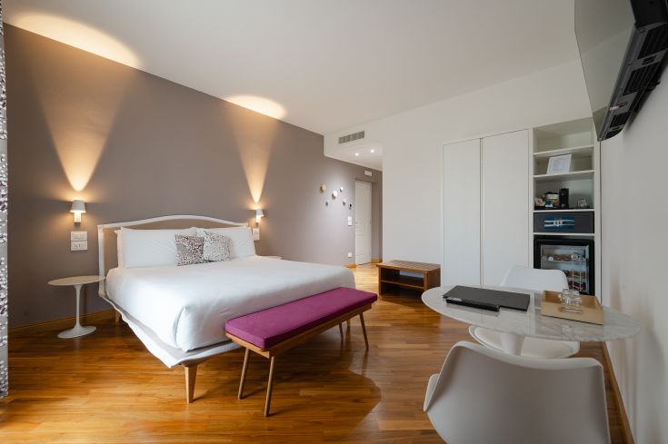 A simple yet functional bedroom featuring a double bed and a relaxing area.