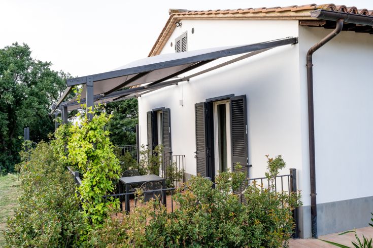 A rustic agriturismo blending tradition with modernity, surrounded by olive trees and typical Italian vegetation.