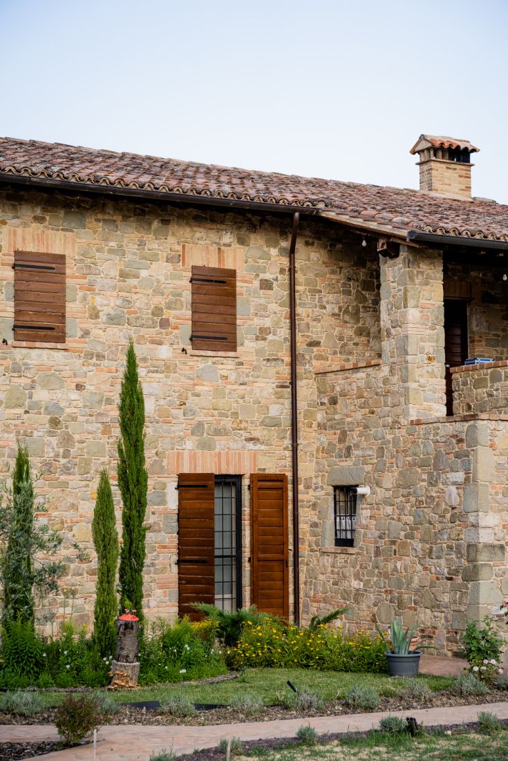 A stone farmhouse with a well-maintained garden, perfect for enjoying the surrounding nature.