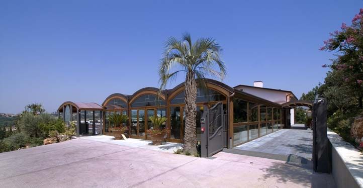 Une résidence moderne plongée dans la nature, avec des arbres et une vue panoramique sur la campagne ombrienne.