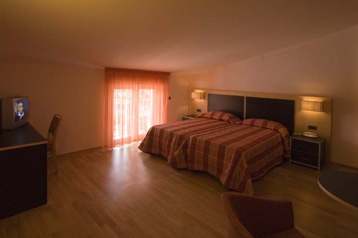 Une chambre simple avec des lits doubles et un éclairage naturel.