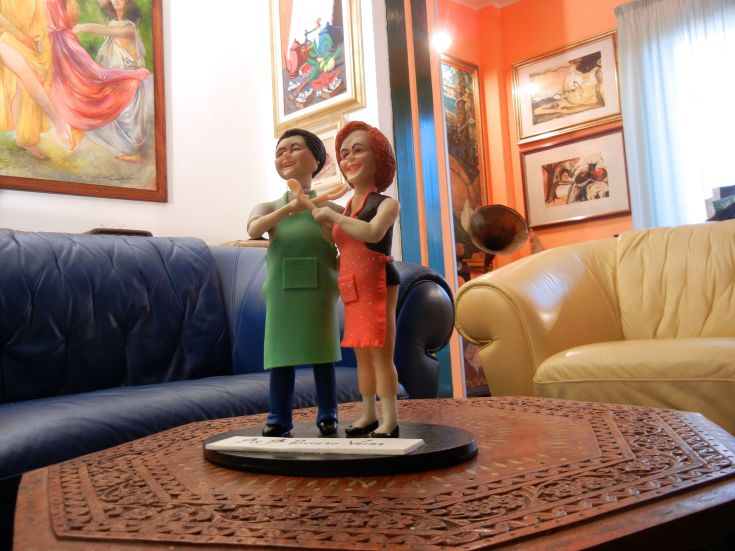 Une sculpture d'un couple souriant dans un environnement chaleureux décoré d'éléments simples.