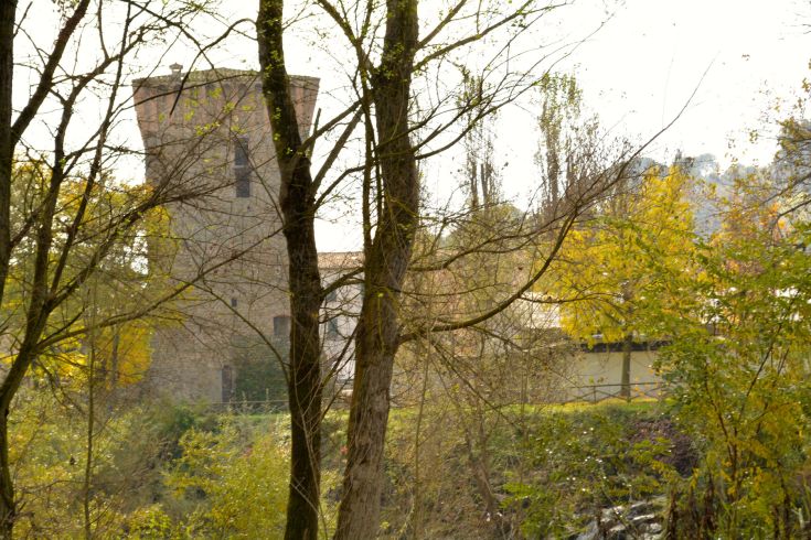 Un palais historique entouré d'arbres et de verdure, avec des nuances de couleurs automnales.