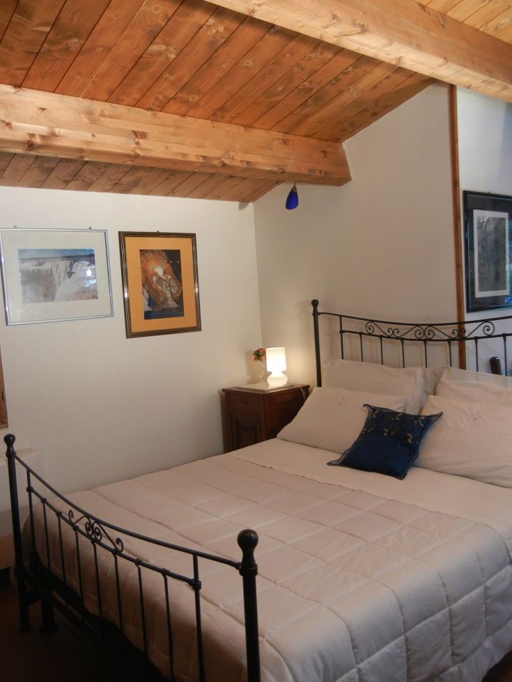 Chambre simple avec sol en bois et décoration épurée. Parfaite pour un séjour tranquille et confortable.