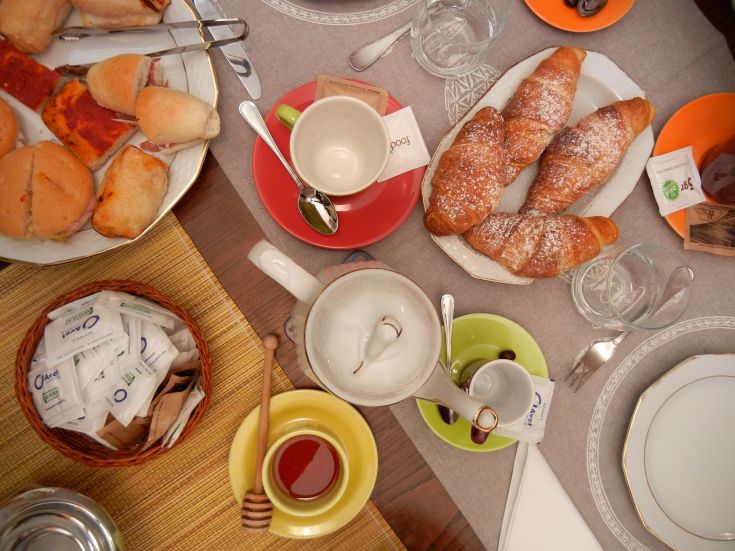 Un petit déjeuner copieux et varié avec des pâtisseries et du thé, dans une ambiance chaleureuse et accueillante.