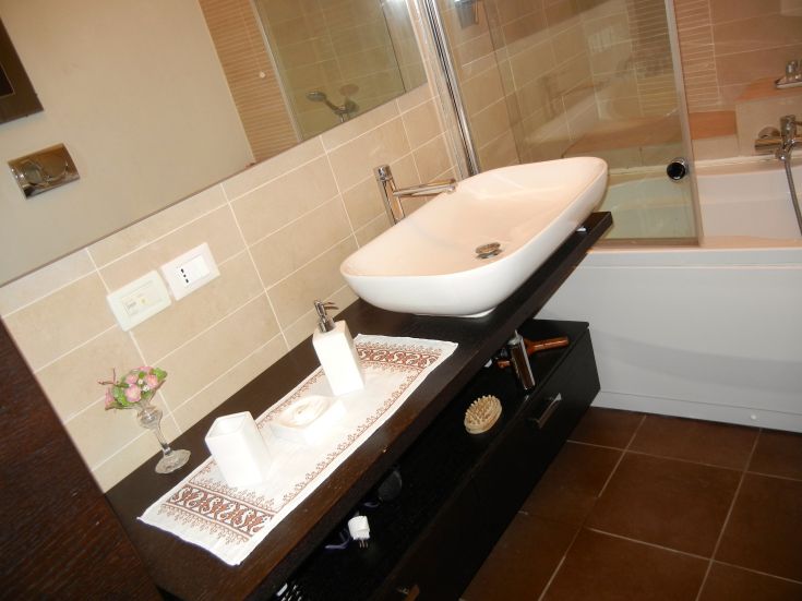 Une salle de bain moderne avec un design simple et contemporain, équipée d'un lavabo et d'une baignoire, axée sur la fonctionnalité et le confort.