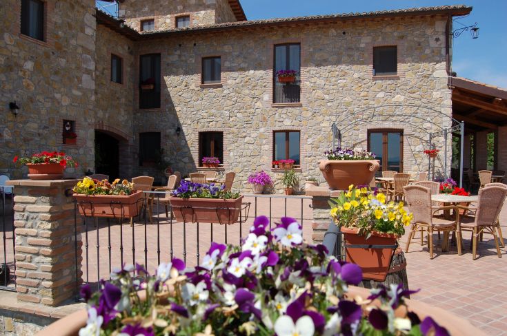 Szene des Agriturismo mit Blumen und Außentischen, ideal für entspannende Momente in der Natur.