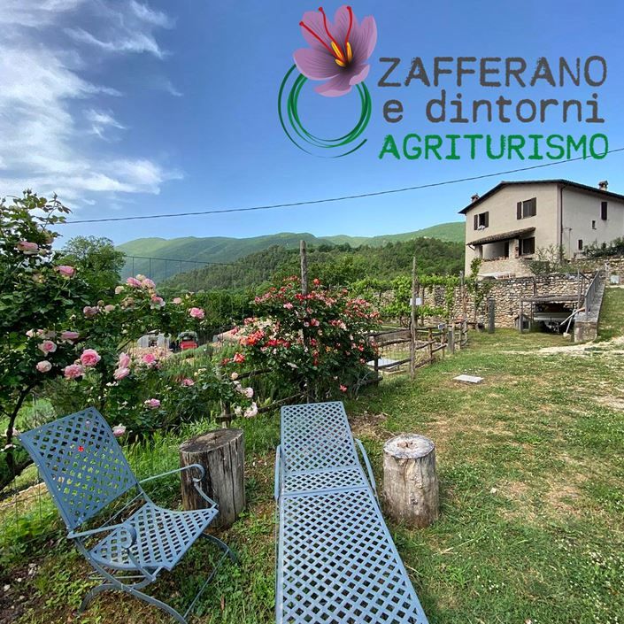 A farmhouse surrounded by greenery, trees, and mountains, offering a peaceful outdoor experience.