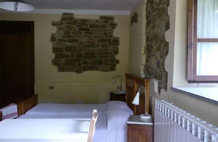 Cozy room with stone walls and simple decor, perfect for a peaceful stay.