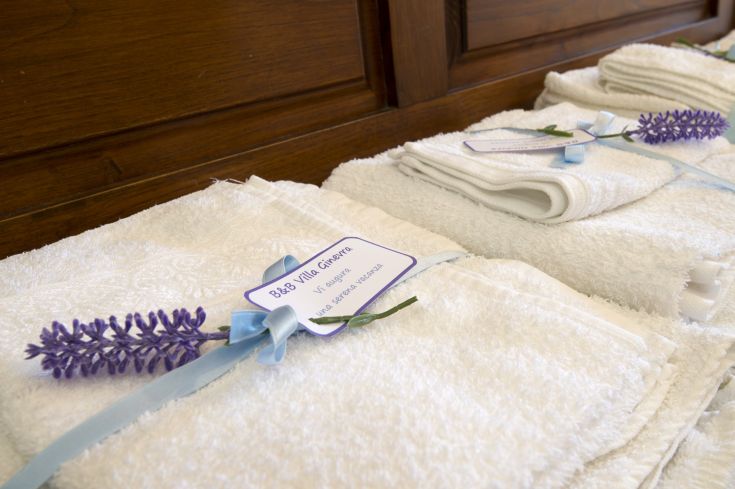 White folded towels decorated with lavender flowers and a note for the B&B.