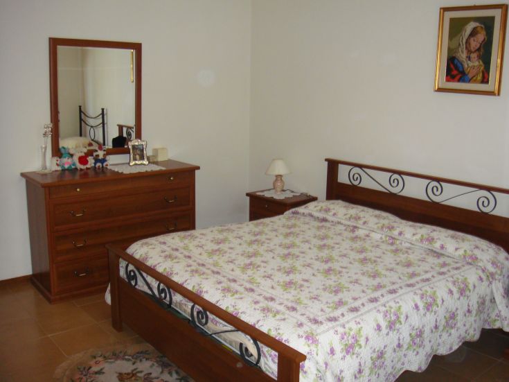 Simple room with wooden beds and floral decorations, perfect for a peaceful stay.