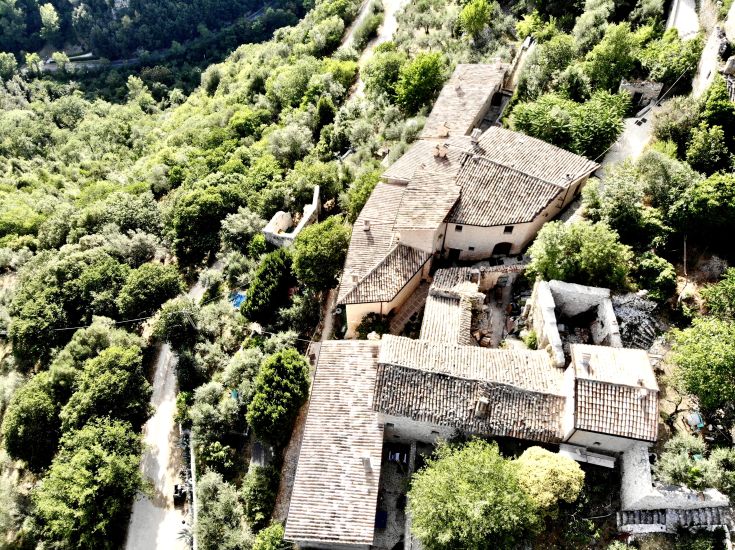 Un village rénové, auparavant abandonné, entouré de verdure luxuriante et soigneusement restauré.