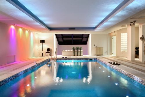 Un ambiente accogliente con una piscina, illuminazione soffusa e spazi dedicati al relax.