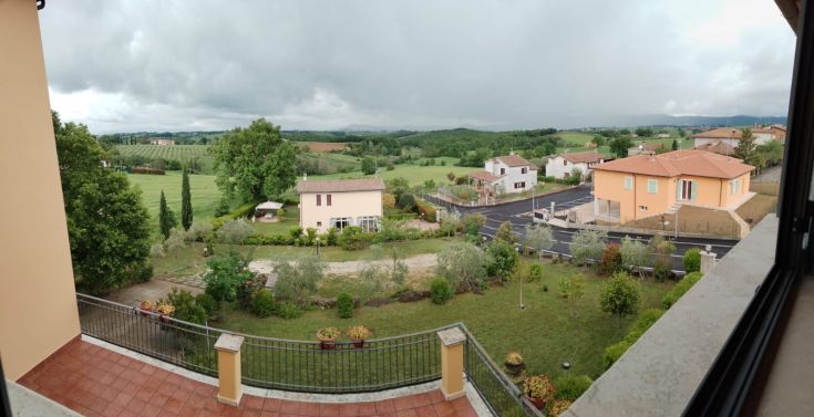 Panorama of the Umbrian hills, featuring typical houses and lush green vegetation.