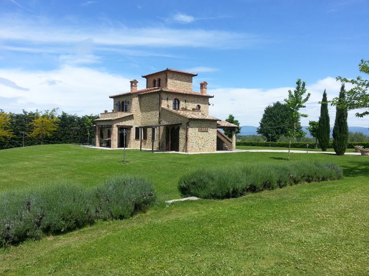 Abitazione in pietra circondata dal verde, con panorama sulle colline circostanti in un contesto tranquillo.