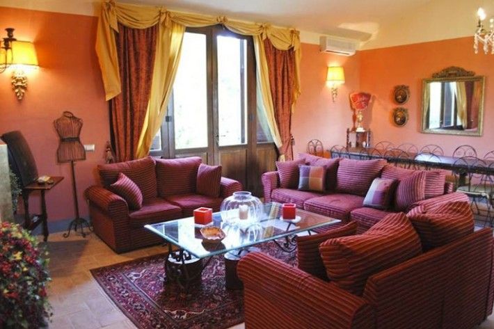 Un salotto spazioso con divani a righe, decorazioni semplici e ampie finestre che permettono alla luce di entrare.