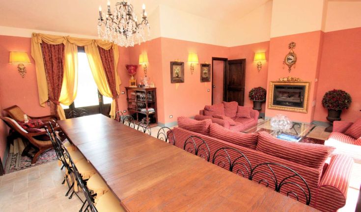 Ambiente confortevole con divani a righe, tavolo in legno e decorazioni sobrie, adatto a momenti di socializzazione.