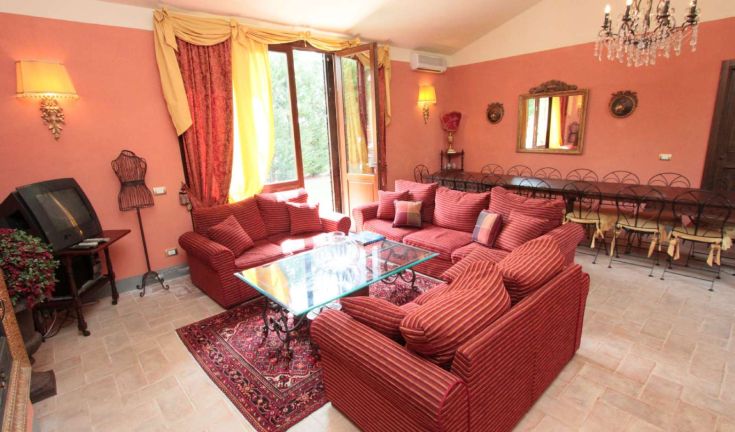 Ampie zone interne di una villa con arredamento sobrio e panorama sul giardino.