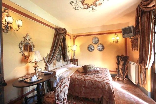 Camera con letti ben rifiniti e illuminazione calda. Atmosfera accogliente e confortevole.