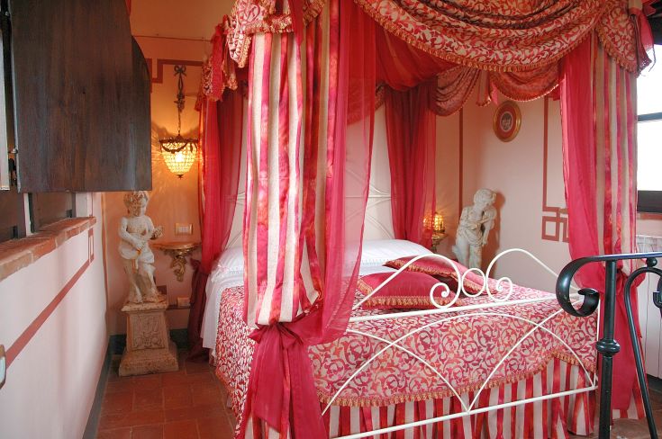 Camera accogliente con letto a baldacchino e decorazioni sobrie, in un ambiente rilassante.