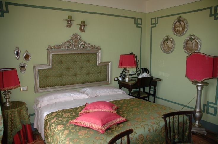 Camera dal design semplice e confortevole con letti a baldacchino, mobili discreti e tonalità calde.