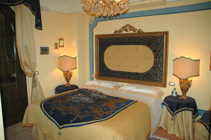 Camera accogliente con letti a baldacchino e decorazioni sobrie, adatta per un soggiorno rilassante.