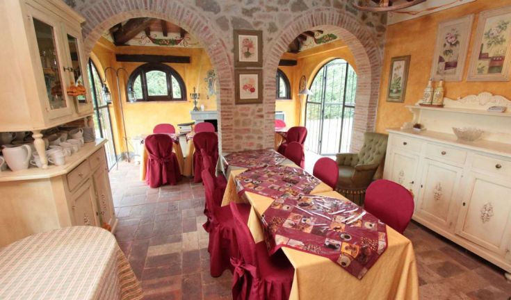 Ambiente sereno con tavoli semplici e decorazioni sobrie, perfetto per riunioni familiari.