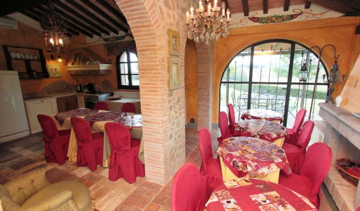 Ambiente confortevole con tavoli e sedie curate, adatto a pranzi conviviali.