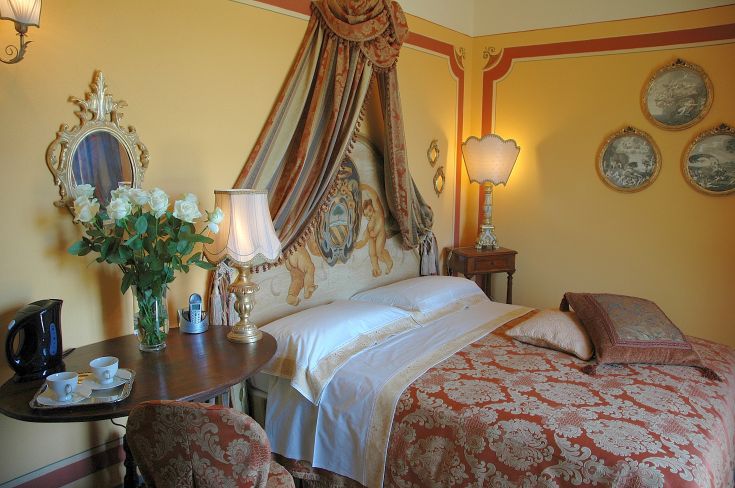 Camera da letto con letti a baldacchino e arredi dalle linee classiche, ideale per momenti di relax.