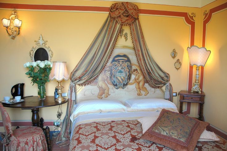Camera con letti a baldacchino e decorazioni semplici. Atmosfera accogliente e confortevole.